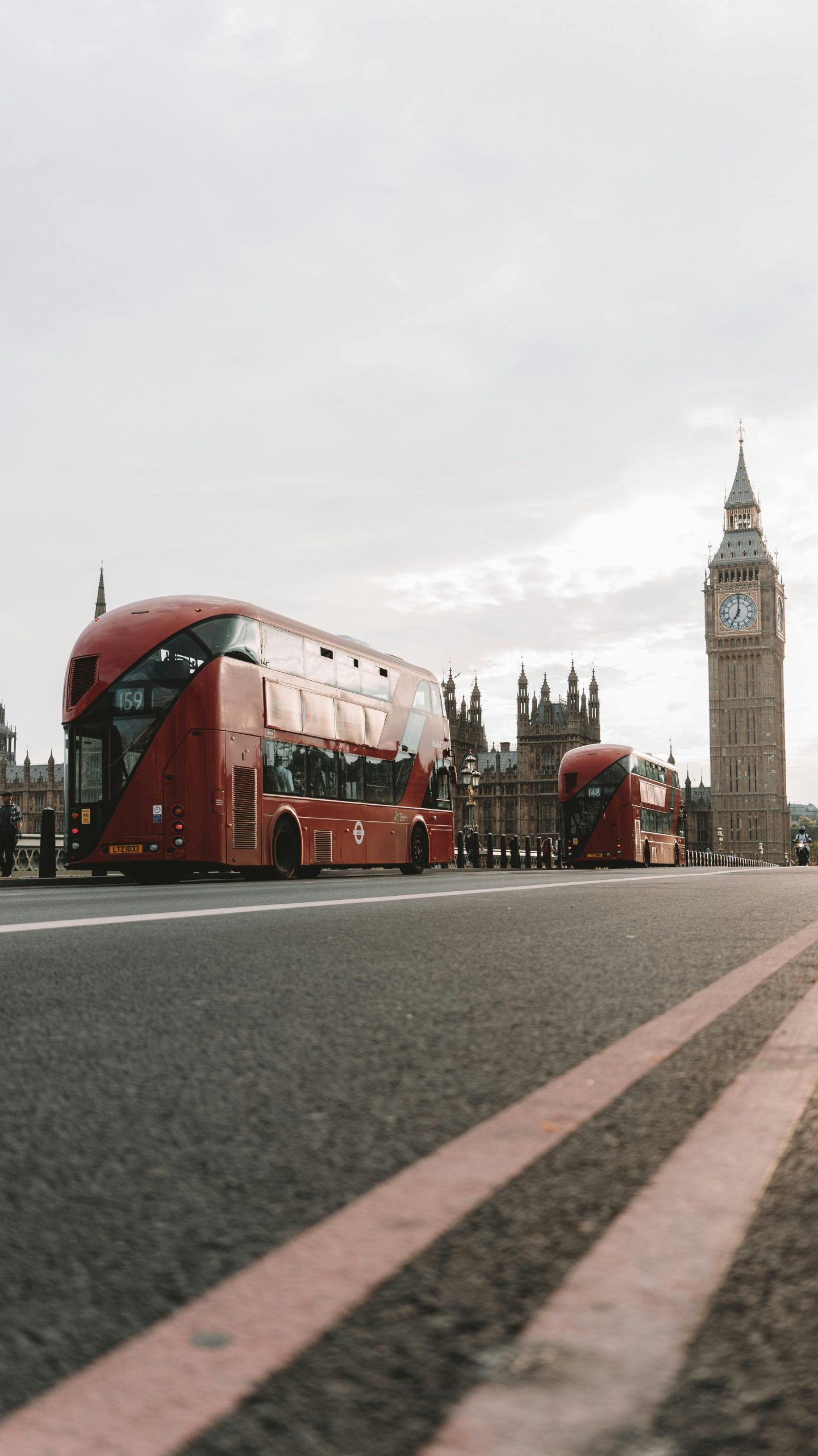 Red double-decker buses on Westminster Bridge with Big Ben in the background, London.